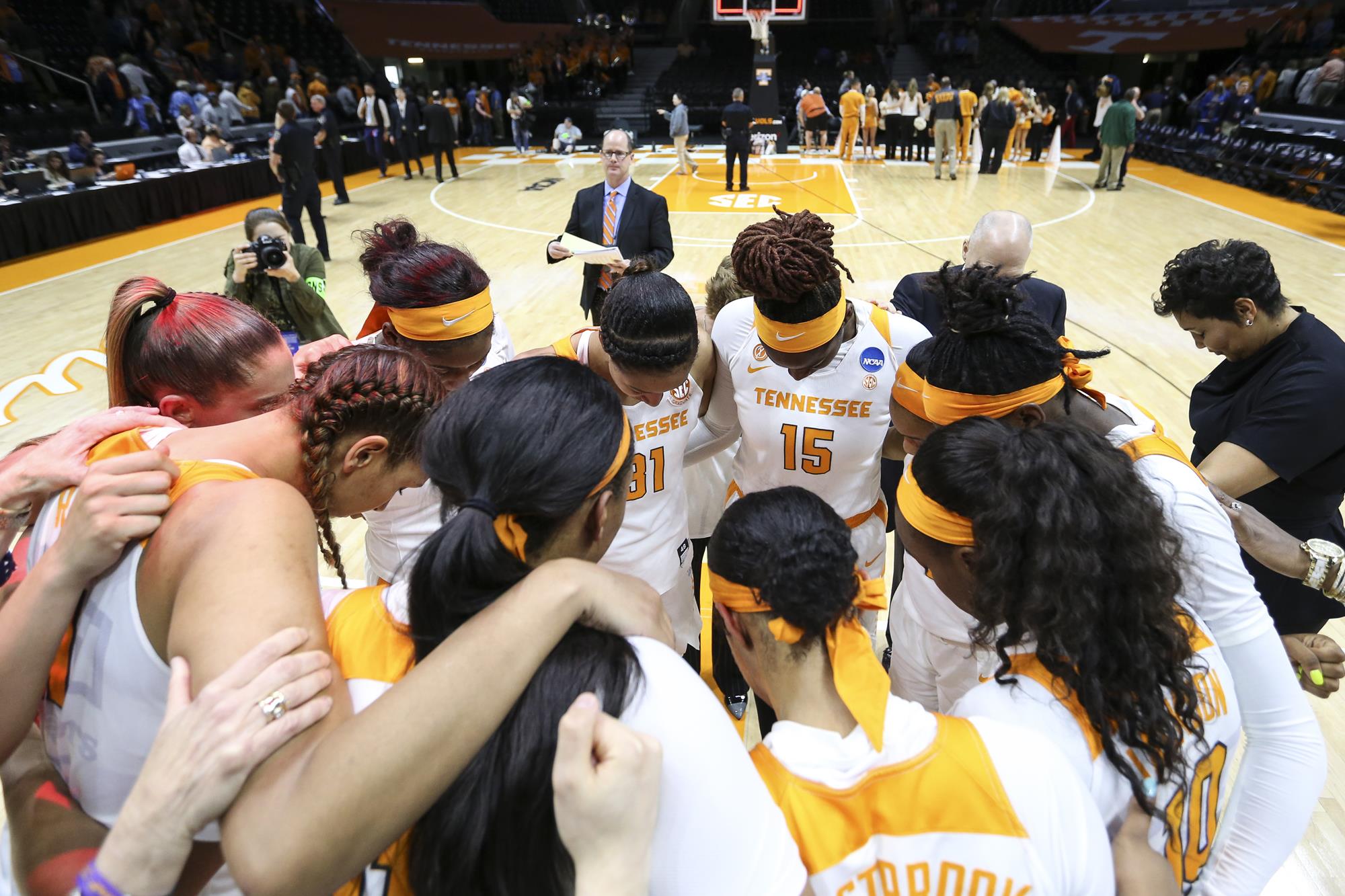 Eric Trainer approaching the Tennessee basketball postgame huddle to conduct postgame interviews after a win over Liberty.